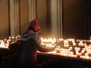 Kinder entzünden im Salzburger Dom eine Kerze für ein verstorbenes Familienmitglied